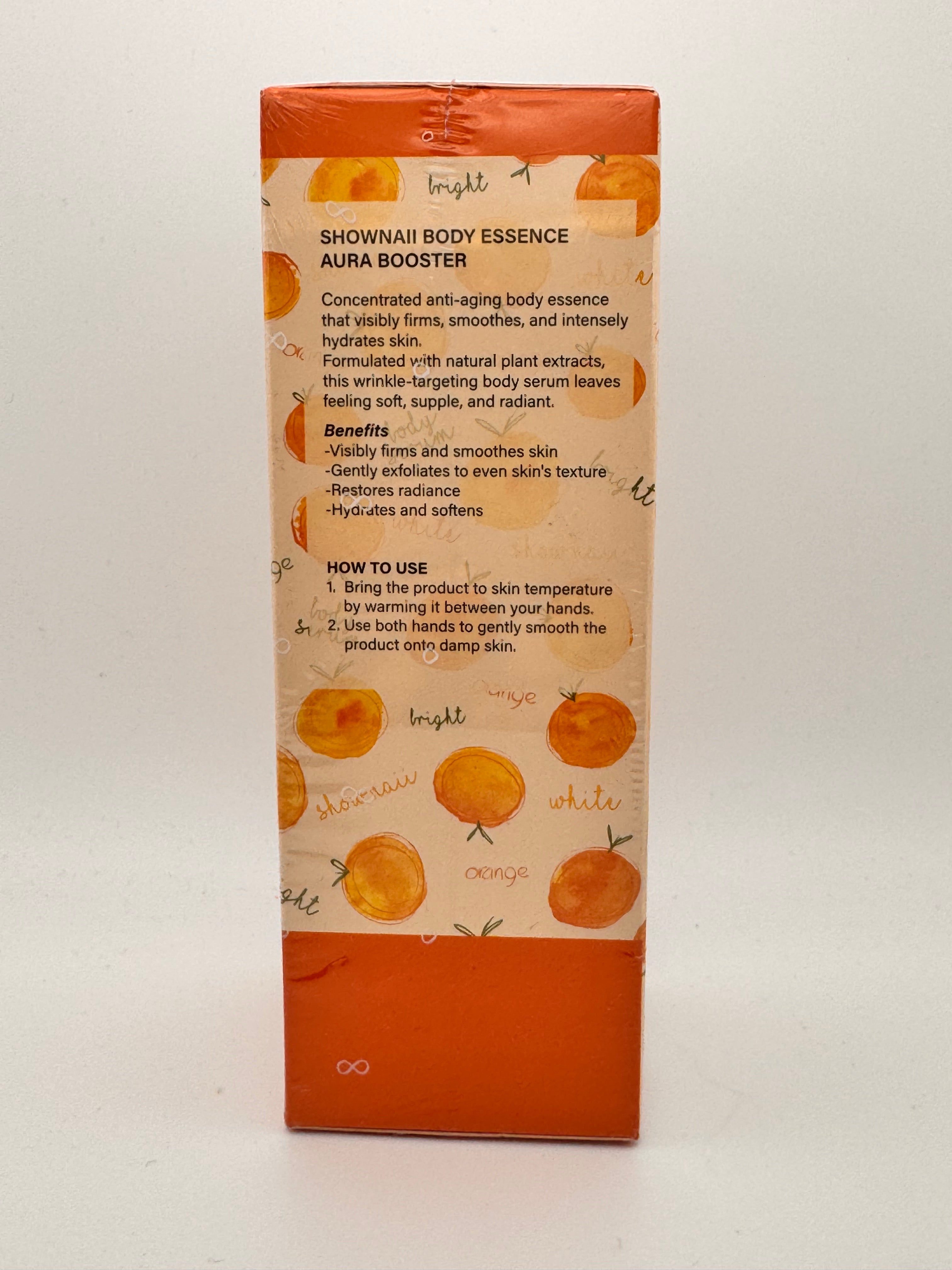 "Aura Booster Body Essence box close-up highlighting brightening complex and aura glow formula"
